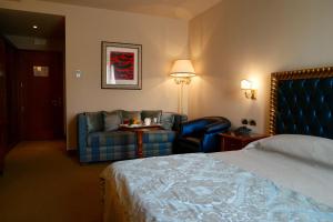Habitación de hotel con cama y silla en Santa Caterina Park Hotel, en Sarzana
