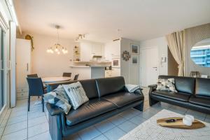 a living room with a couch and a table at Gezellig en knus app vlakbij centrum Nieuwpoort! in Nieuwpoort