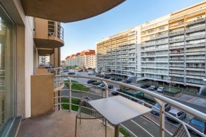 a balcony with a table and a view of a city at Gezellig en knus app vlakbij centrum Nieuwpoort! in Nieuwpoort