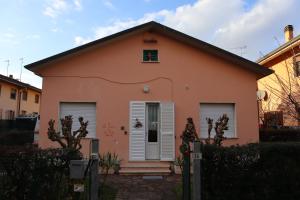 ein kleines rosafarbenes Haus mit weißen Türen und Fenstern in der Unterkunft La Casina di Zia Zita in Pieve a Nievole