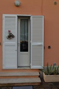 a white door on a house with a porch at La Casina di Zia Zita in Pieve a Nievole