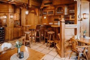 a bar in a restaurant with wooden walls and wooden stools at Landhotel Rügheim in Rügheim