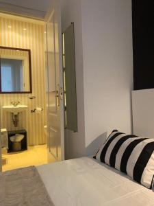 um quarto com uma cama e uma casa de banho com um lavatório em Sor Angela Apartment em Madri