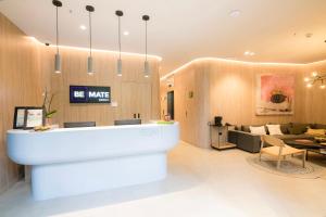 a lobby with a reception desk and a living room at Be Mate Medellín in Medellín