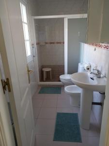 een witte badkamer met 2 toiletten en een wastafel bij Seafront Garden and Sea views in Torrox