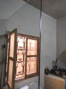 a bathroom with a window next to a toilet at Dar Naima in Fez