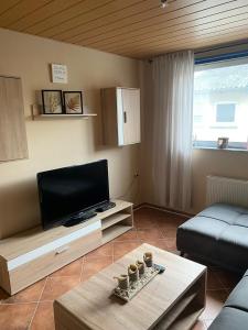 a living room with a flat screen tv and a couch at Ferienwohnung Schanz in Konken