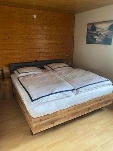 a large bed in a room with a wooden wall at Ferienwohnung Schanz in Konken