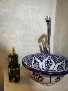 a blue and white sink sitting next to a candle at Dar Naima in Fez