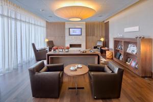 a living room with chairs and a table in a room at EPIC SANA Lisboa Hotel in Lisbon