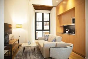ein Wohnzimmer mit einer Couch und einem Tisch in der Unterkunft nQn Aparts & Suites Sevilla in Sevilla