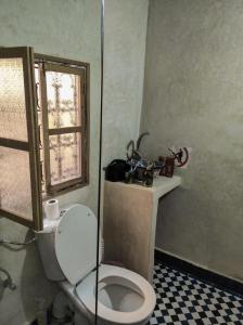 baño con aseo blanco y ventana en Dar Naima, en Fez
