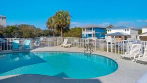 a swimming pool with chairs and a fence at Float Away in Panama City Beach