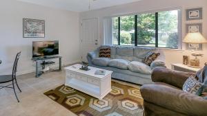 a living room with a couch and a tv at Hidden Beach 117 in Santa Rosa Beach