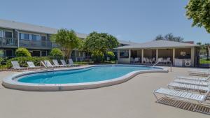 a swimming pool with lounge chairs in front of a building at Hidden Beach 117 in Santa Rosa Beach