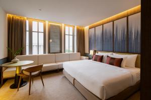 una camera d'albergo con un grande letto e un divano di Hotel MOCO a Udon Thani
