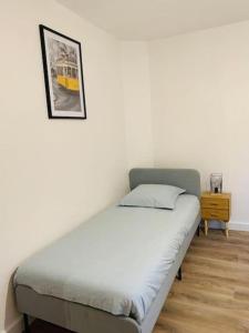 uma cama num quarto com uma fotografia na parede em Gîte meublé 1 à 4 pers à Sierck-Les-Bains proche Cattenom Thionville Luxembourg em Sierck-les-Bains