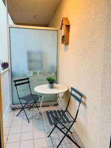 2 Stühle und ein Tisch auf einem Balkon mit einem Tisch in der Unterkunft Gîte meublé 1 à 4 pers à Sierck-Les-Bains proche Cattenom Thionville Luxembourg in Sierck-les-Bains