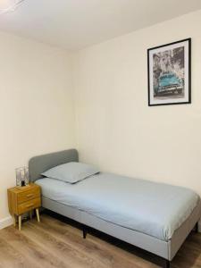 uma cama num quarto com uma fotografia na parede em Gîte meublé 1 à 4 pers à Sierck-Les-Bains proche Cattenom Thionville Luxembourg em Sierck-les-Bains
