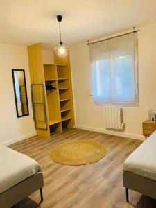 een kamer met 2 bedden, een raam en een tapijt bij Gîte meublé 1 à 4 pers à Sierck-Les-Bains proche Cattenom Thionville Luxembourg in Sierck-les-Bains