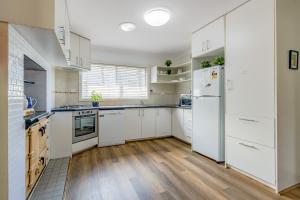 cocina con electrodomésticos blancos y suelo de madera en Sunflower Cottage, en Katoomba 12 fotos más