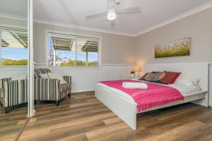 um quarto com uma cama e uma cadeira em Sunflower Cottage em Katoomba