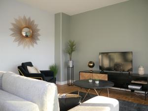 - un salon avec un canapé et une télévision dans l'établissement Appartement Le Céleste 113 - deux chambres, à Ramonville-Saint-Agne
