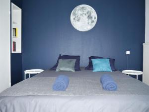 - une chambre avec un grand lit et une lune sur le mur dans l'établissement Appartement Le Céleste 113 - deux chambres, à Ramonville-Saint-Agne