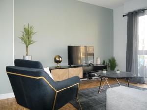 a living room with a couch and a tv and a table at Appartement Le Céleste 113 - deux chambres in Ramonville-Saint-Agne