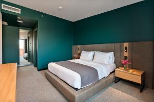 トビリシにあるGraf Hotelの緑の壁のベッドルーム1室(大型ベッド1台付)