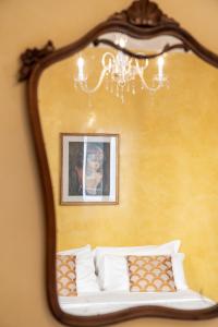 a mirror above a bed with a picture of a child at Palazzo San Luca in Venice