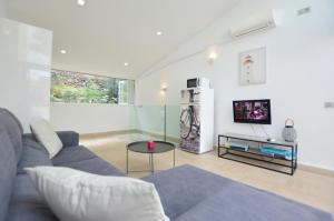 a living room with a couch and a tv at House 200m from Puerto de Sóller Beach in Port de Soller