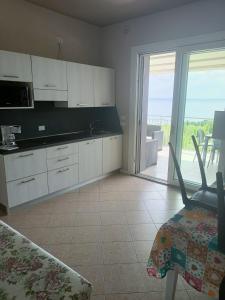 une cuisine avec des placards blancs et une vue sur l'océan. dans l'établissement Villa Molino, à Moniga del Garda