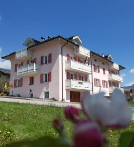 a large white building with red windows and flowers at Casa Vacanze Rosa in Brez
