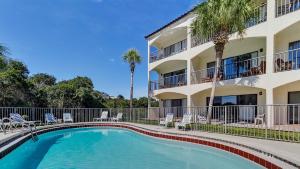 - une piscine en face d'un bâtiment avec des palmiers dans l'établissement Palms C7, à Santa Rosa Beach