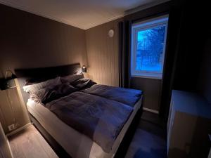 um quarto com uma cama grande e uma janela em Olderfjord Lodge em Russenes
