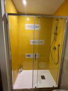 een badkamer met een douche en een gele muur bij Plan B B&B in Napels