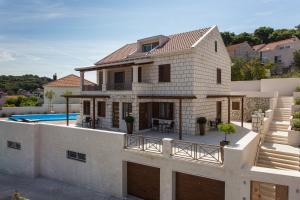 a villa with a swimming pool and a house at Villa Peragro in Dubrovnik