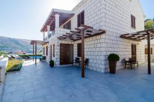 a building with a patio with tables and chairs at Villa Peragro in Dubrovnik