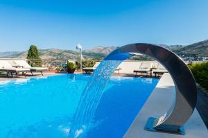una piscina con una fuente de agua en el medio en Villa Peragro, en Dubrovnik
