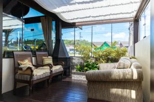 uma sala de estar com cadeiras e uma grande janela em Hotel Premium em Gramado