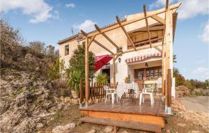 een huis met een houten terras met een tafel en stoelen bij Awesome Home In El Poleo With Outdoor Swimming Pool in Las Higueras