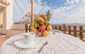 une corbeille de fruits assise sur une table avec une tasse dans l'établissement Awesome Home In El Poleo With Outdoor Swimming Pool, à Las Higueras