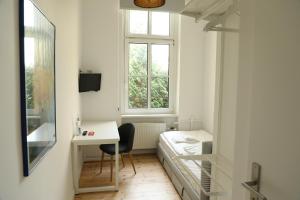 ein kleines Zimmer mit einem Bett, einem Schreibtisch und einem Fenster in der Unterkunft Art Hotel Charlottenburger Hof Berlin in Berlin
