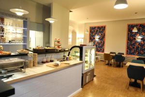 ein Restaurant mit einer Theke, auf der Essen angeboten wird in der Unterkunft Art Hotel Charlottenburger Hof Berlin in Berlin