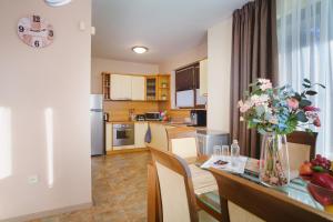 uma cozinha e sala de jantar com uma mesa com um vaso de flores em Villa Topola Bay View em Topola