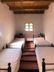 3 łóżka w pokoju z oknem w obiekcie Gite La belle vue Timichi w mieście Timichchi