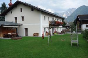 uma casa com um quintal com um parque infantil em frente em Marhof Pustertal em Anras