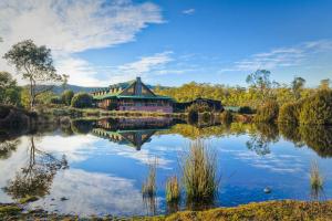 a house on a pond in a park at Peppers Cradle Mountain Lodge in Cradle Mountain