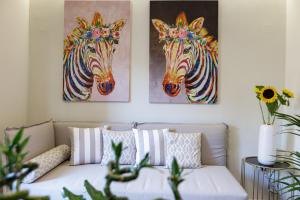 una sala de estar con 2 pinturas de cebras en la pared en Queen Stella Luxury Homes, en Rethymno